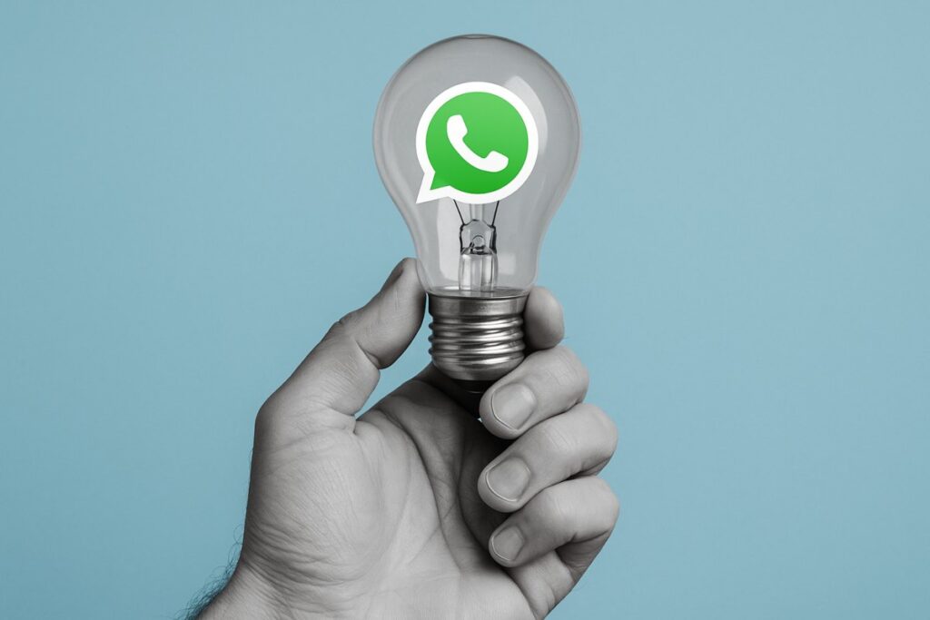 Illustrazione di una mano che tiene una lampadina (idea) e logo WhatsApp all'interno