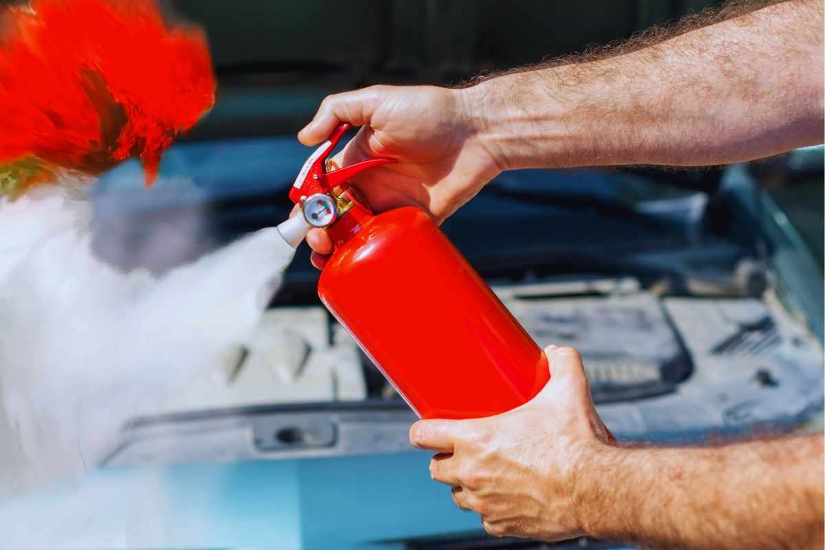 Uomo che spegne incendio con estintore