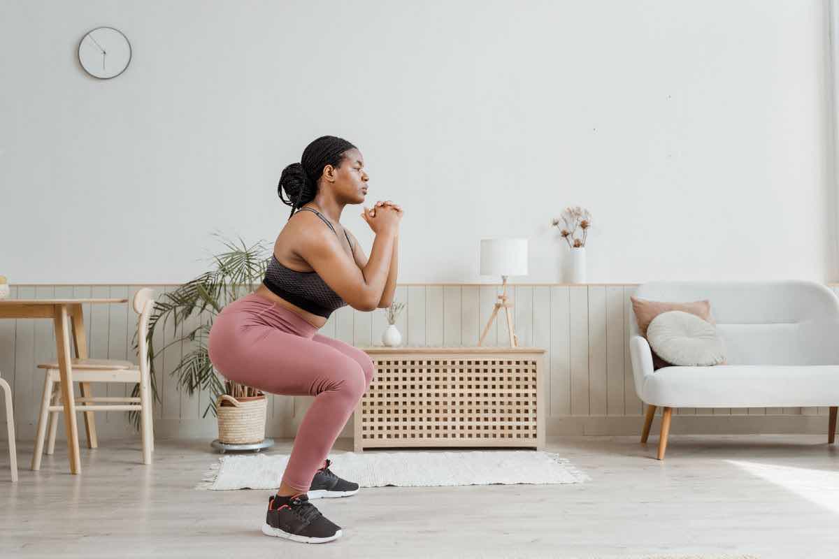 Donna che fa squat in casa
