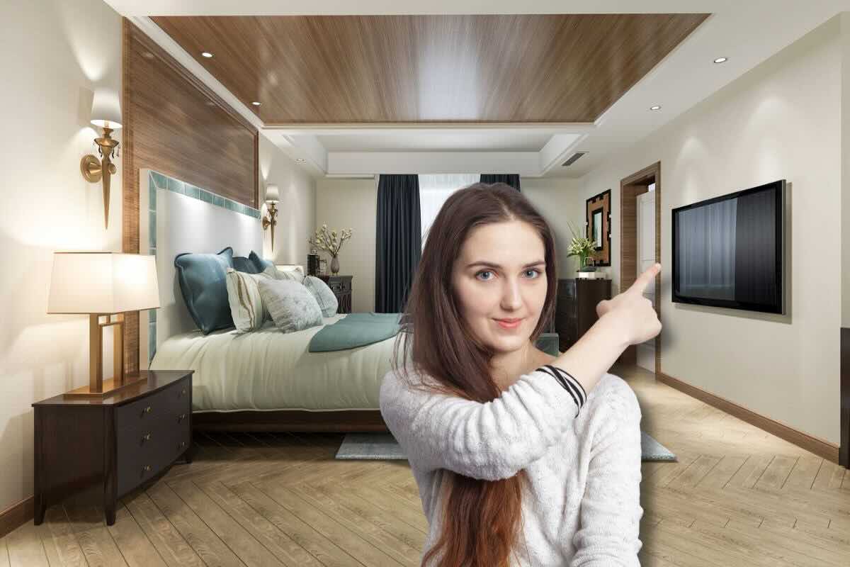 Donna che indica televisore davanti al letto