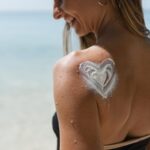 Donna con crema solare sulla spalla