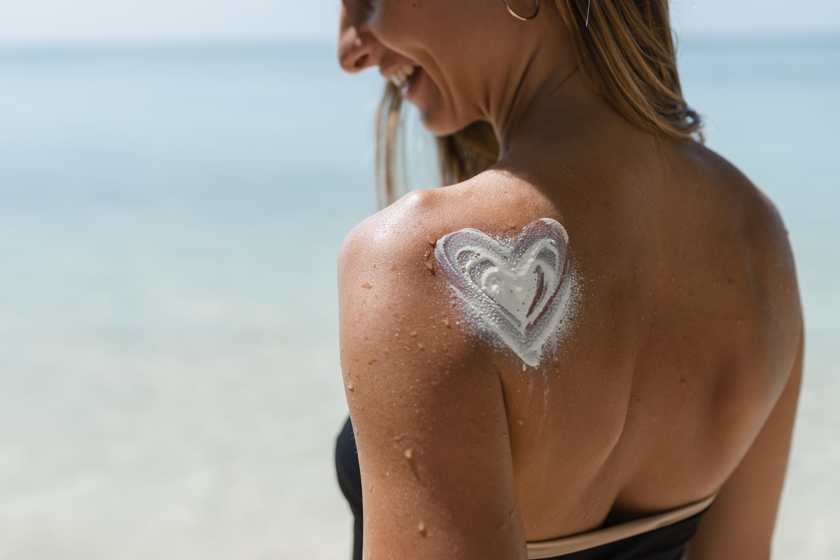 Donna con crema solare sulla spalla